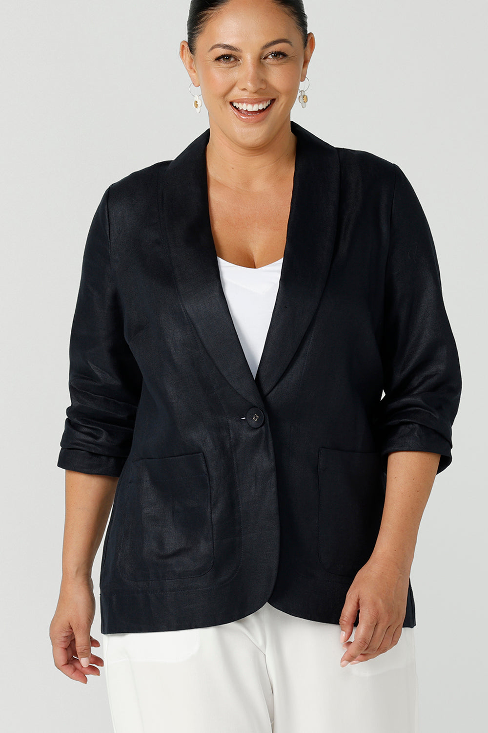Close up of a size 12 woman wearing a soft linen blazer jacket with a tailored design. A transeasonal linen work jacket, in a beautiful midnight navy colour. Australian-made using sustainable 100% linen fabric. Size-inclusive fashion 8-24 for corporate casual workwear.