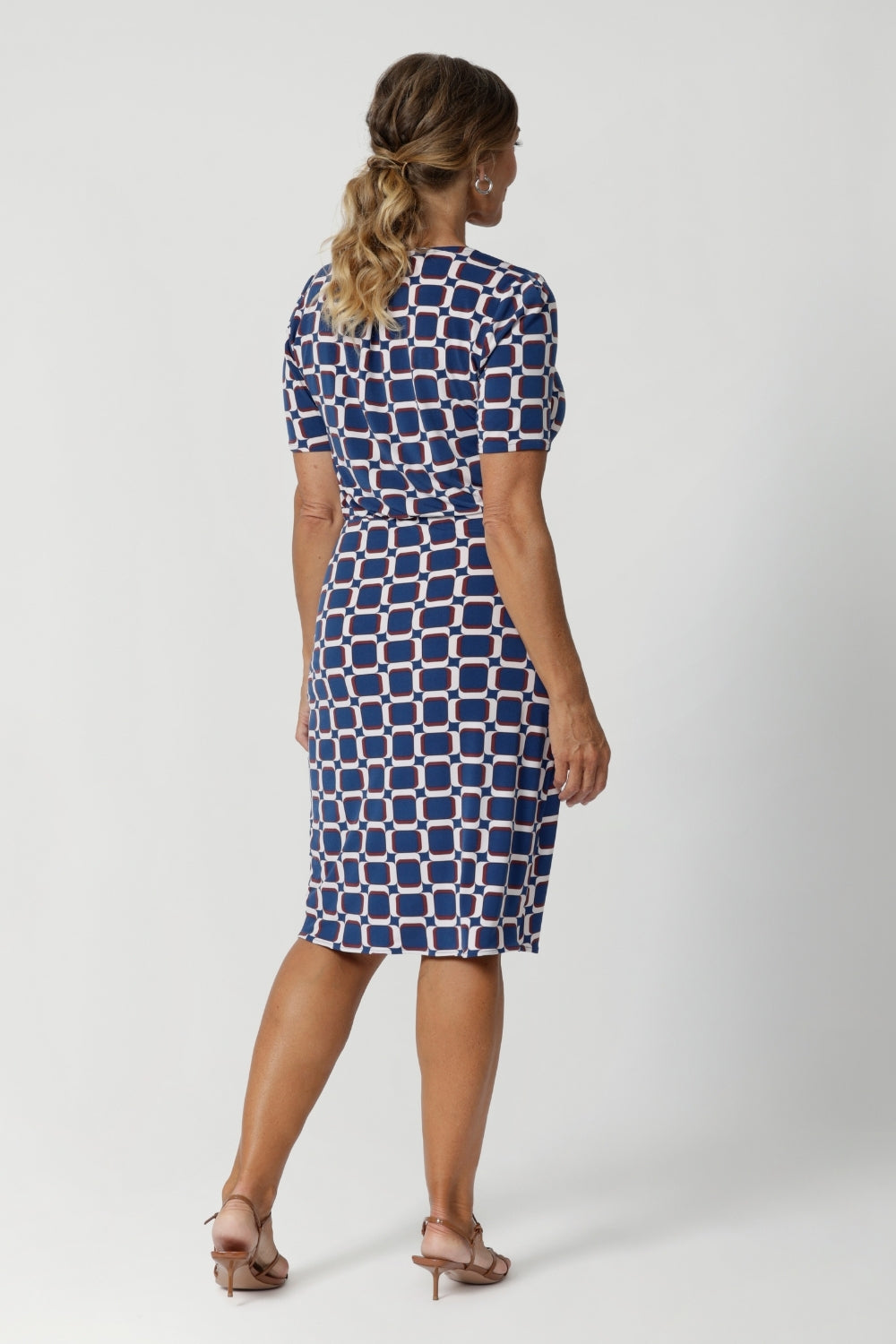 A centre-back tailored tuck enhances the fit, adding structure and a flattering silhouette. The dress also features subtle stretch at the waist, creating a smooth, defined shape that flatters your figure. Model in images wears printed dress with brown kitten heels and silver accessories.