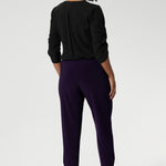 Now available in 2 lengths. A size 10 woman wears the Indi Pant in Amethyst, made from a jersey stretch fabric, with pleat front and cuffed leg opening. Made in Australia for women size 8-24. 
