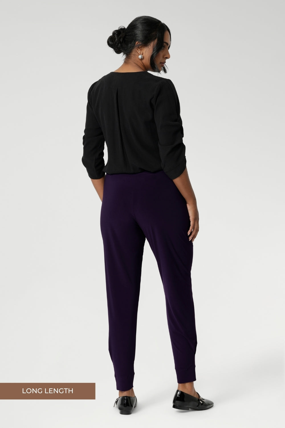 Now available in 2 lengths. A size 10 woman wears the Indi Pant in Amethyst, made from a jersey stretch fabric, with pleat front and cuffed leg opening. Made in Australia for women size 8-24. 