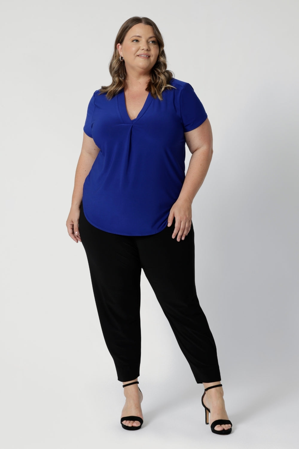 Full body image of 40 year old woman wears classic black Indi Pant. High quality fabric used to make these garments is dry touch jersey. Made in Australia for woman in Australia & New Zealand. Sizes range from 8 - 24 with plus and petite friendly sizes considered and ready to shop.