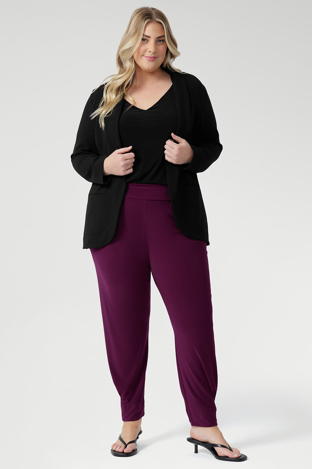 Plus size woman wears Indi Pants in Magenta that feature a tapered leg design. Easy care pants come in two different lengths to accommodate a variety of heights, available in sizes 8-24.