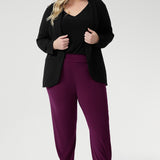 Plus size woman wears Indi Pants in Magenta that feature a tapered leg design. Easy care pants come in two different lengths to accommodate a variety of heights, available in sizes 8-24.