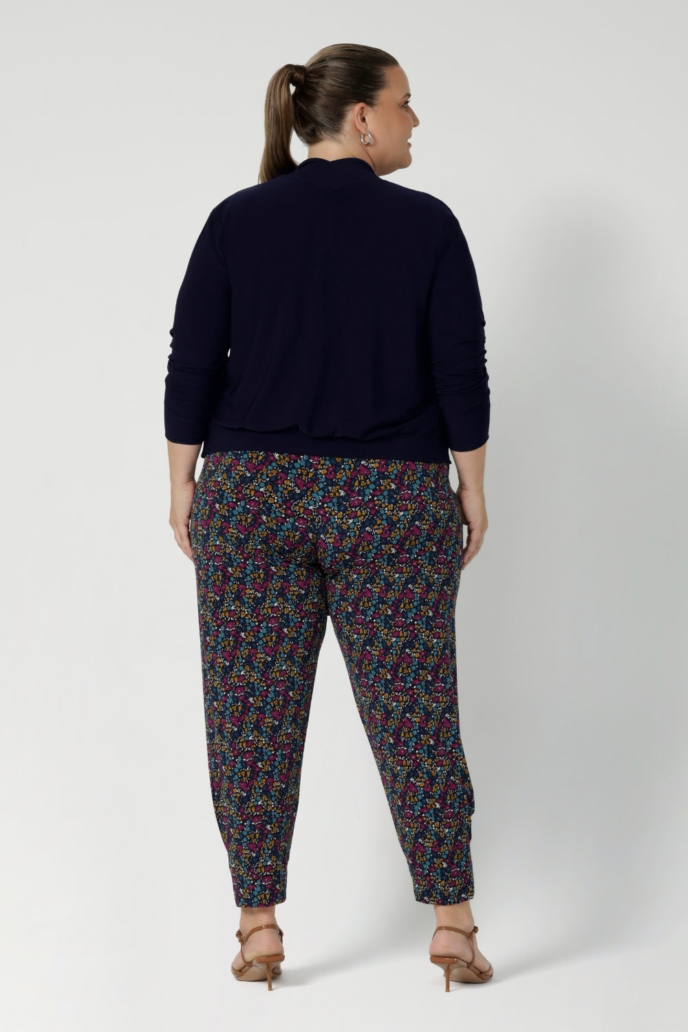 Tapped leg pant seen on plus sized model paired with navy jacket. These pants are versatile enough to be dressed up or down, making them a must-have for travel, work, or casual outings. Whether you're on the go or looking for a chic and comfy addition to your wardrobe. Available in 8-24.