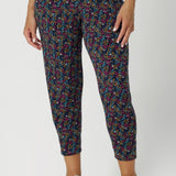 Made from a soft, stretchy fabric with the Harmony print, which features a navy base with vibrant floral details in magenta, mustard, blue, and vanilla, the fabric feels luxurious yet breathable, making it ideal for long days of wear. The mid-rise pull-on waist with a double-layer waistband provides support and comfort, while the front gathers add a touch of sophistication.