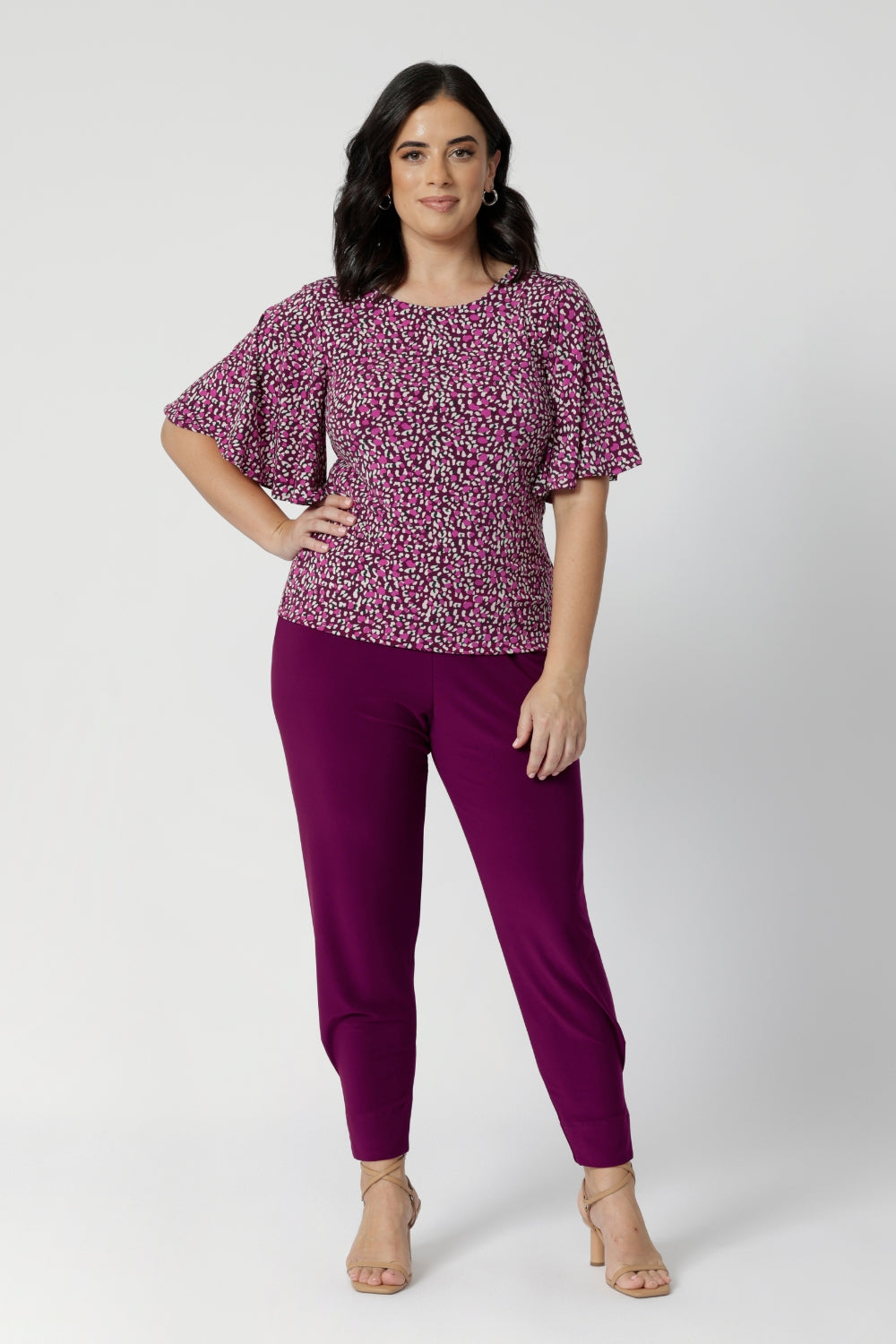 Designed with a mid-rise fit, Indi features a pull-on waist with a double-layer waistband for a smooth and secure fit. The front gathers add a subtle touch of detail, giving the pants a relaxed, flattering look, while the relaxed crotch ensures freedom of movement. Petite woman wears travel ready pants available in sizes 8-24.