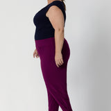 Plus size woman wears Indi Pants in Magenta that feature a tapered leg design. Easy care pants come in two different lengths to accommodate a variety of heights, available in sizes 8-24.