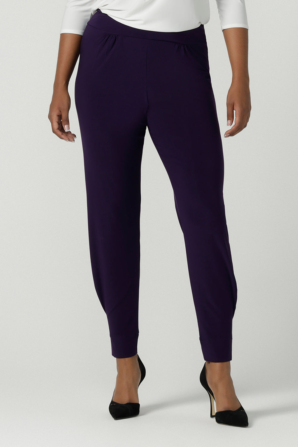 Close up of a size 10 woman wearing the Indi Pant in Amethyst. An Indi pant in amethyst with a mid rise waistband, tapered ankle balloon leg style. A made in Australia pant for women. Perfect travel friendly non-crease pant. Size 8-10.