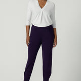 A size 10 woman wears the Indi Pant in Amethyst. An Indi pant in amethyst with a mid rise waistband, tapered ankle balloon leg style. A made in Australia pant for women. Perfect travel friendly non-crease pant.  Size 8-10. 