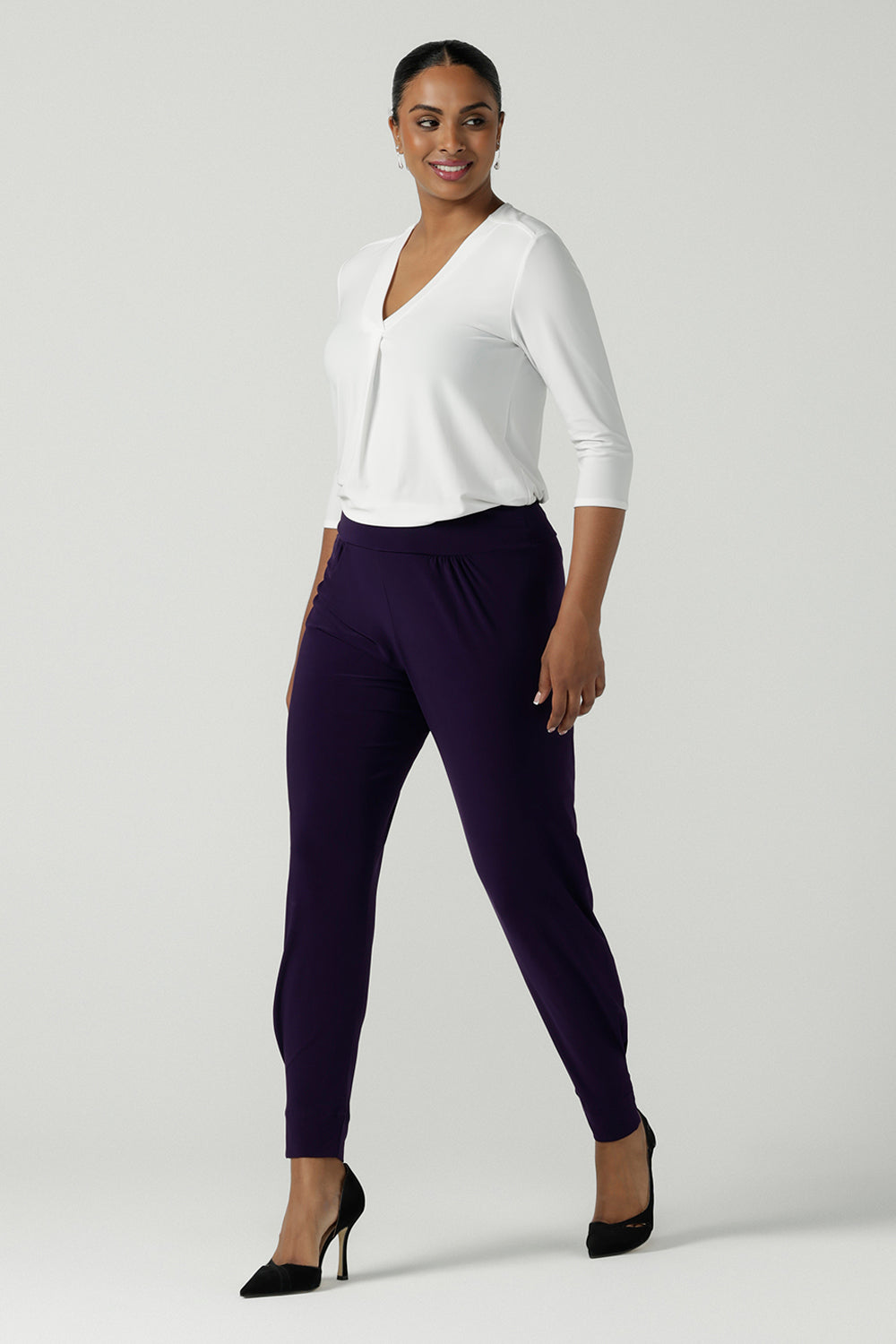 Close up of a size 10 woman wearing the Indi Pant in Amethyst. An Indi pant in amethyst with a mid rise waistband, tapered ankle balloon leg style. A made in Australia pant for women. Perfect travel friendly non-crease pant. Size 8-10.