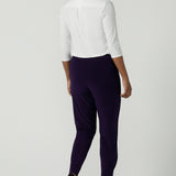 Back view of a size 10 woman wearing the Indi Pant in Amethyst. An Indi pant in amethyst with a mid rise waistband, tapered ankle balloon leg style. A made in Australia pant for women. Perfect travel friendly non-crease pant. Size 8-10.