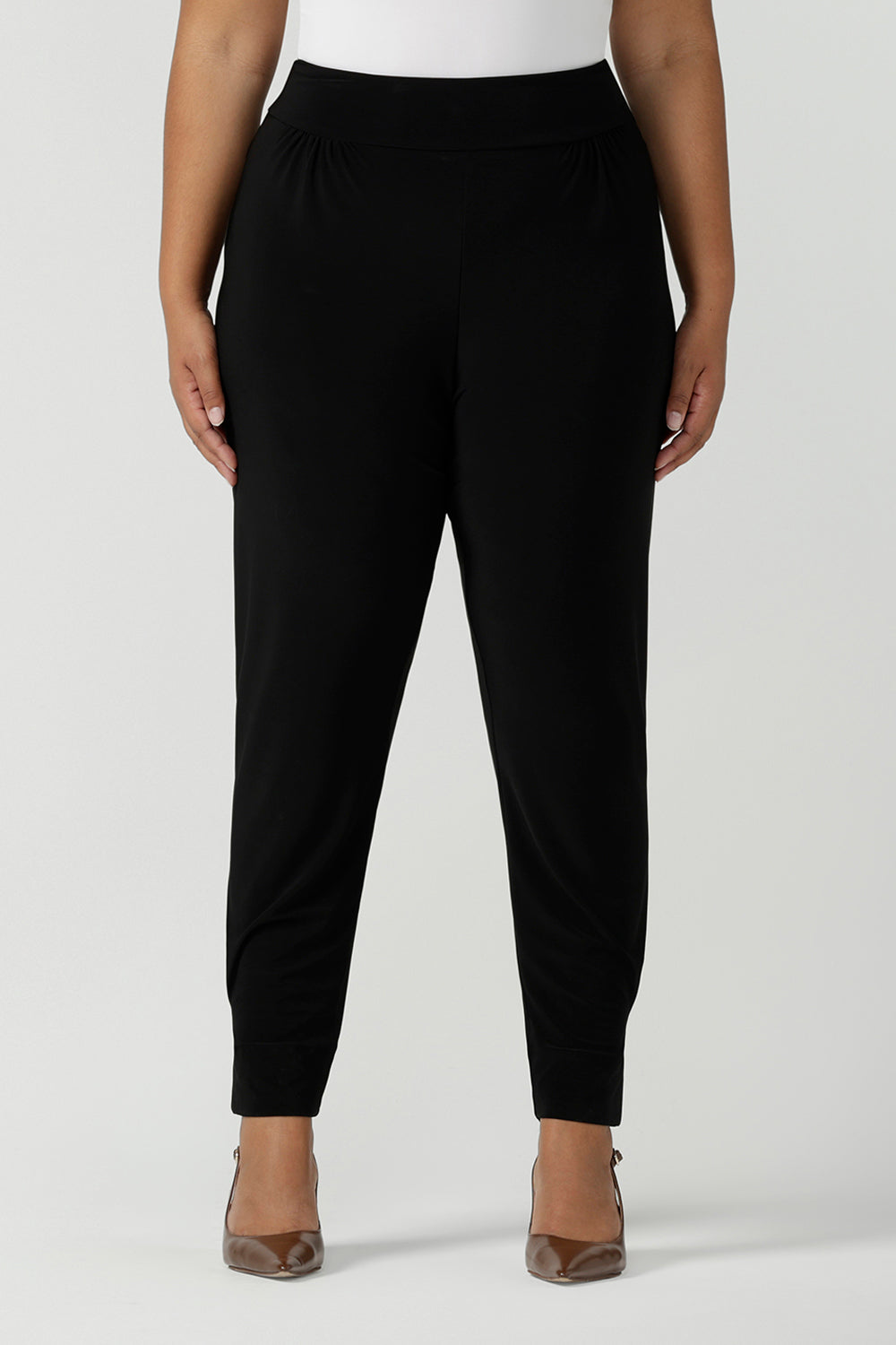 Designed as a full length travel pant for tall women. A size 18 curvy woman wears great pants for travel, these dropped crotch, single seam black pants are made stretchy jersey for ultimate comfort. Worn with a white bamboo jersey top , shop these comfy black pants for your travel and capsule wardrobe now!
