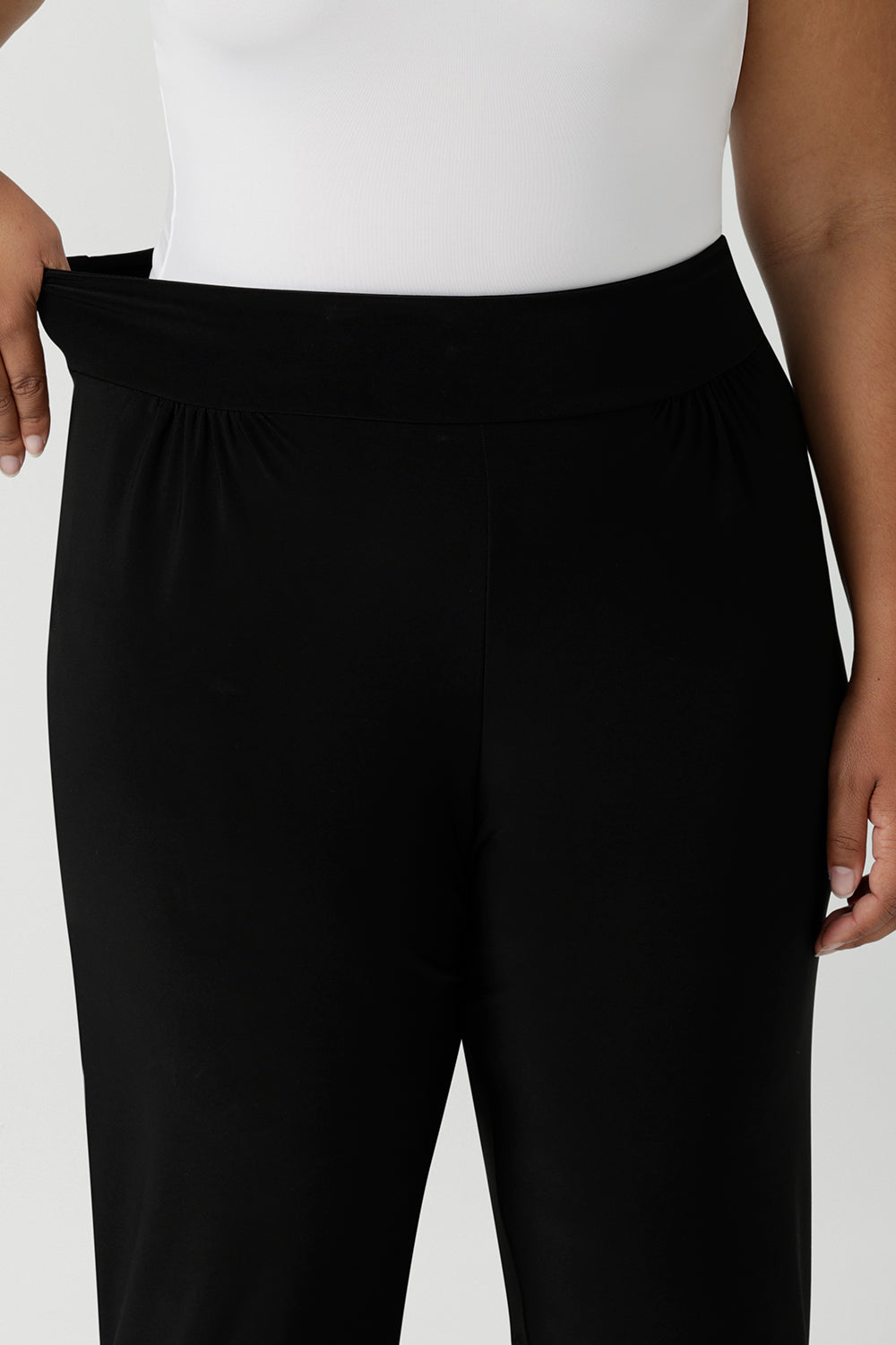 Close up of the stretchy waistband of great pants for travel, these dropped crotch, single seam black pants are made stretchy jersey for ultimate comfort. shop these comfy black pants for your travel and capsule wardrobe now!