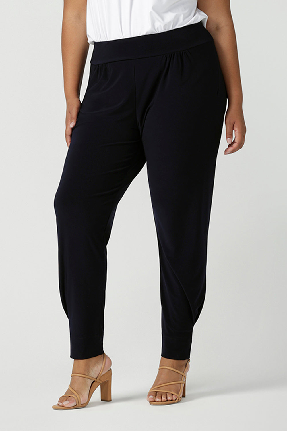 A size 18 curvy woman wears great pants for travel, these dropped crotch, single seam navy pants are made stretchy jersey for ultimate comfort. shop these comfy navy pants for your travel and capsule wardrobe now! Available in sizes 8-24.