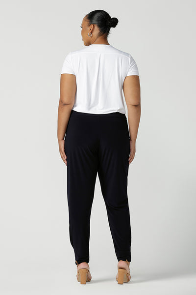 Back view of a size 18 curvy woman wears great pants for travel, these dropped crotch, single seam navy pants are made stretchy jersey for ultimate comfort. Worn with a white bamboo jersey top , shop these comfy navy pants for your travel and capsule wardrobe now! Available in sizes 8-24.