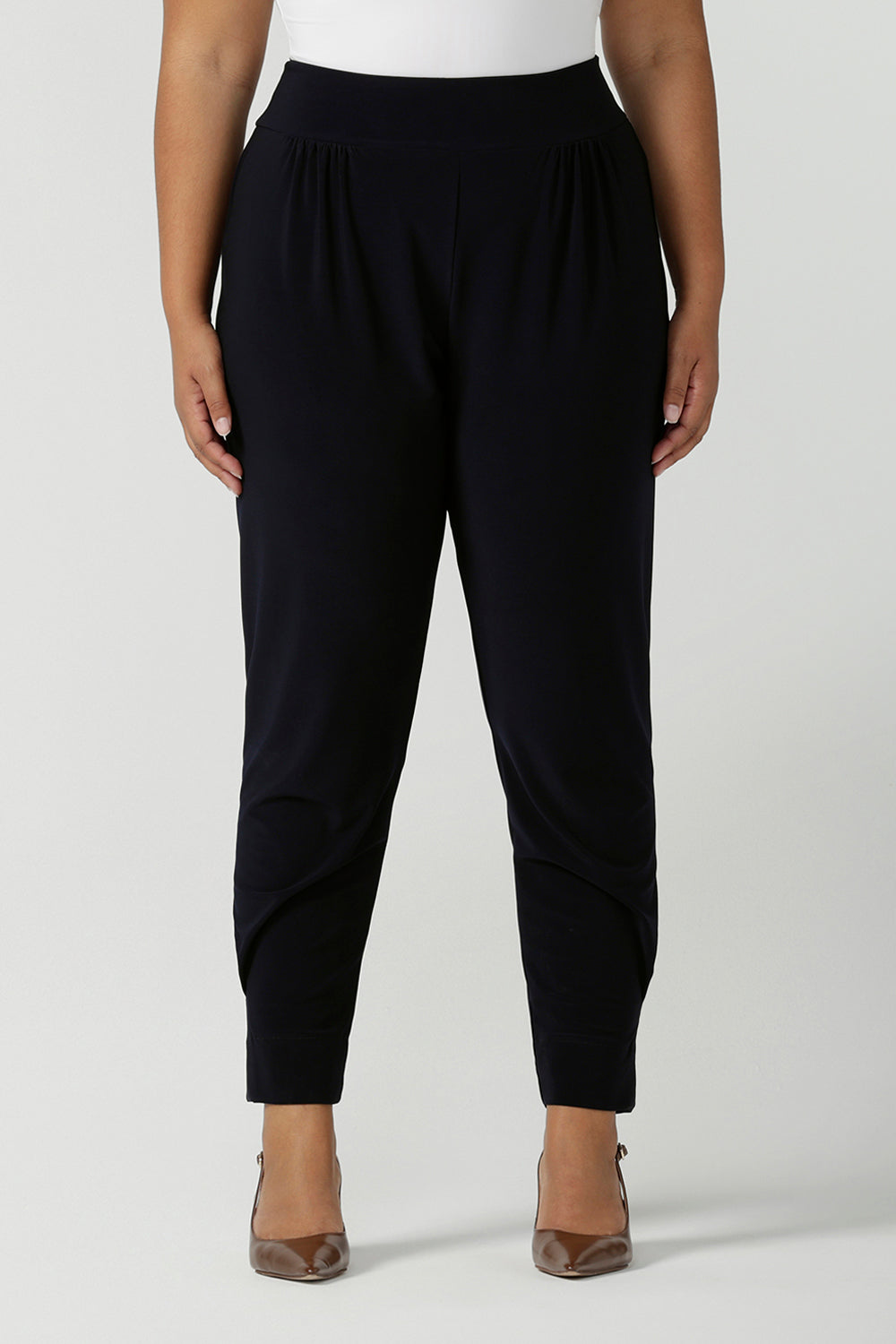 Designed as a full length travel pant for tall women. A size 18 curvy woman wears great pants for travel, these dropped crotch, single seam navy pants are made stretchy jersey for ultimate comfort. Worn with a white bamboo jersey top , shop these comfy navy pants for your travel and capsule wardrobe now! Available in sizes 8-24.
