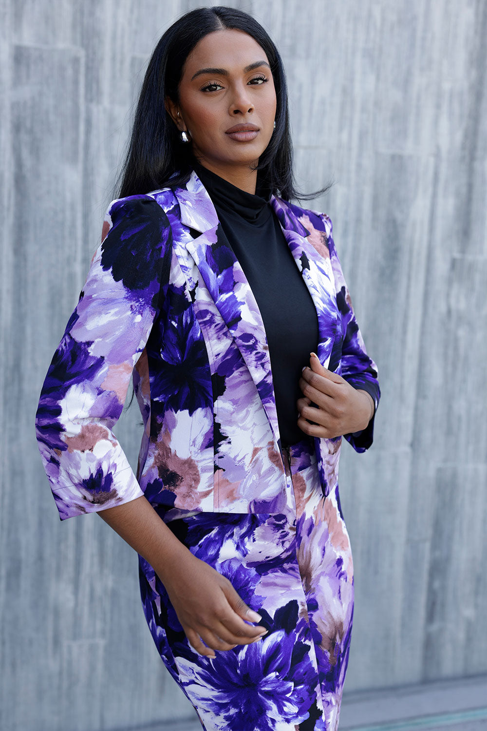 A size 10 woman wears a Benni Jacket in Jacaranda. With 3/4 sleeves and a floral purple print. Made in Australia for a size inclusive fashion label Leina & Fleur size 8-24.