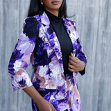 A size 10 woman wears a Benni Jacket in Jacaranda as a mother of the bride outfit, styled with the lilac print midi skirt.  With 3/4 sleeves and a floral purple print. Made in Australia for a size inclusive fashion label Leina & Fleur size 8-24.