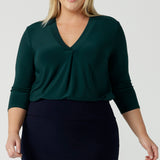 A size 18 woman wears the Jaime Top in Alpine with a soft pleated neckline and 3/4 sleeves. A fitted Andi skirt in Navy. Easy care jersey that is perfect for work to weekend. Made in Australia for  women size 8 - 24. 