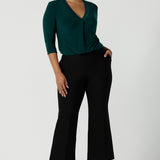 A size 10 woman wears the Jaime Top in Alpine paired back with the Troy pant in Black. The Jaime has a black v-neckline and pleated front with 3/4 sleeves in Alpine jersey. Easy care and great for work to weekend. Made in Australia for women size 8 - 24. 