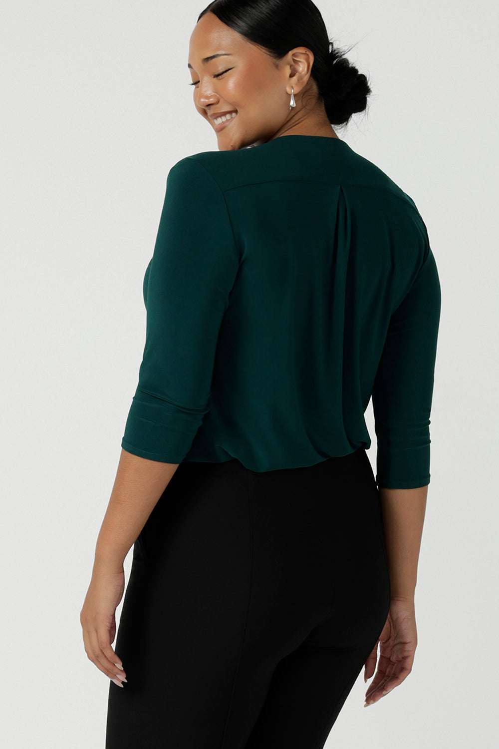 A size 10 woman wears the Jaime Top in Alpine paired back with the Troy pant in Black. The Jaime has a black v-neckline and pleated front with 3/4 sleeves in Alpine jersey. Easy care and great for work to weekend. Made in Australia for women size 8 - 24.