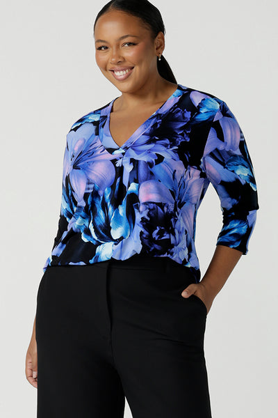 Size 16 woman wears the Jaime Top in Blue Lily, a V-necklien style with a pleat front and 3/4 sleeves. The perfect workwear corporate top for women with easy care jersey. Made in Australia. Corporate to plus size. Size 8 - 24