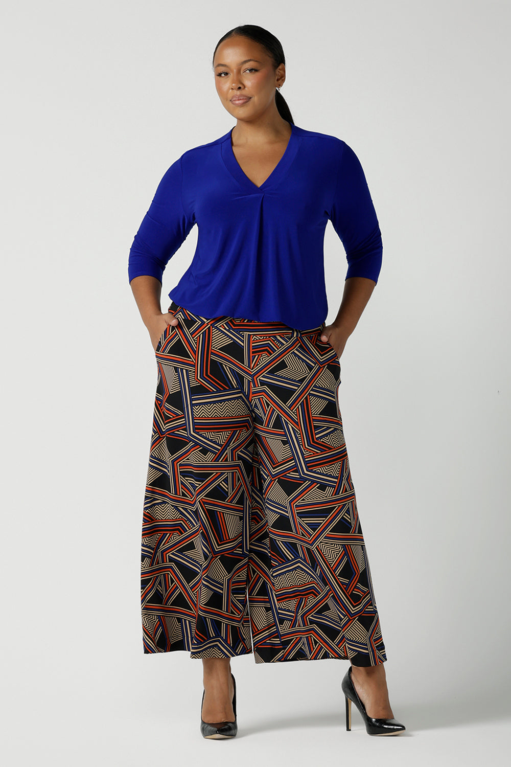 Size 16 woman wears the Dany Culotte in Trixie, a printed Jersey work pant with a geometric pattern. Wide leg with functional pockets and wide waistband. Cropped length and petite height friendly. Made in Australia for women size 8 - 24.