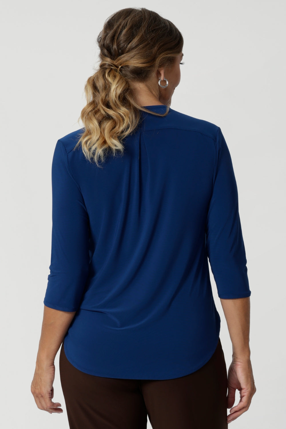 A shoulder yoke with a centre-back tailored tuck adds an extra dimension to the top, creating a flattering and sophisticated fit. The curved shirttail hemline enhances the overall shape of the top, providing a flattering silhouette that pairs beautifully with high-waisted pants, skirts, or tucked into your favourite trousers