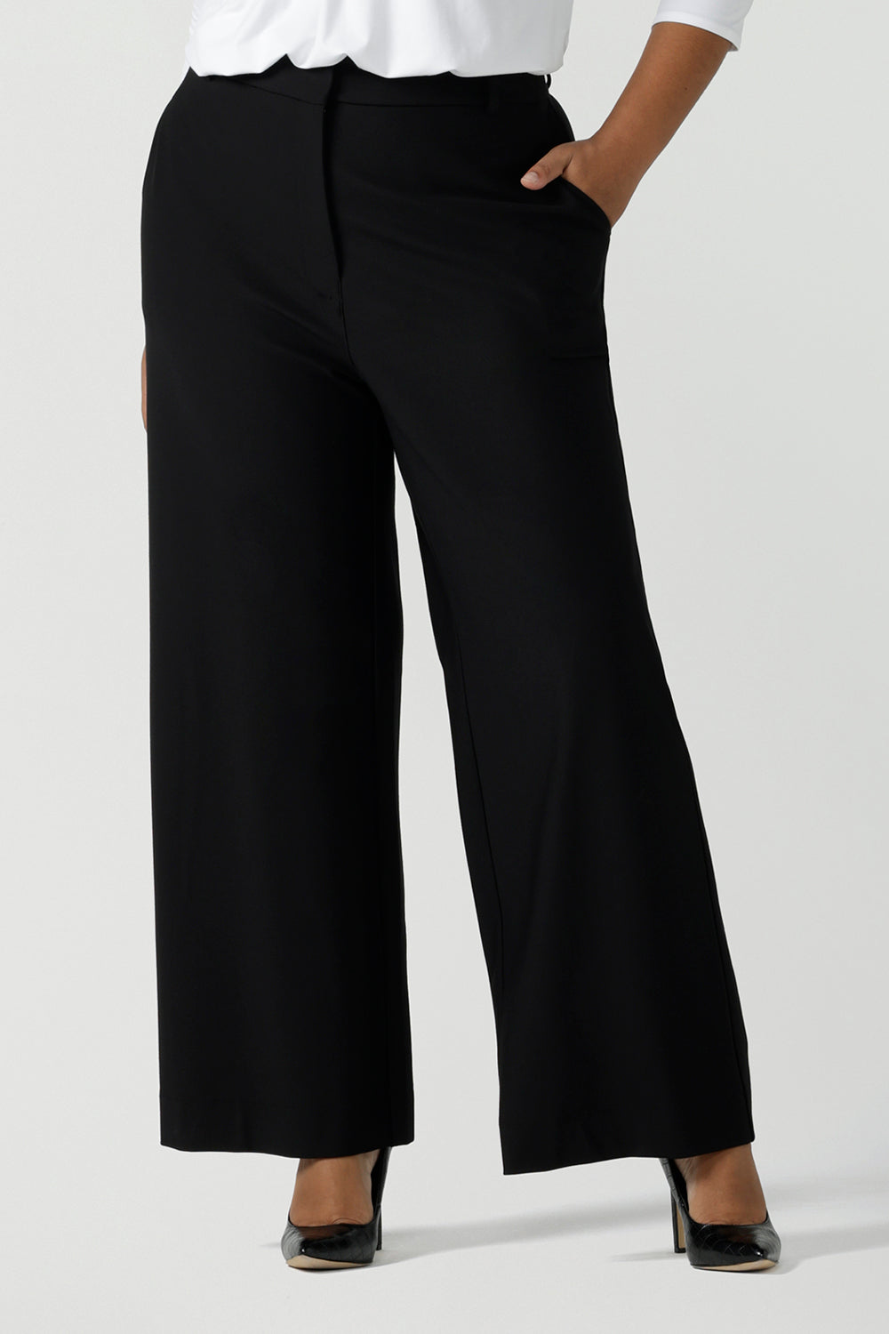 Close up of a size 16 woman wearing the Kade pant in black, a softly tailored black pant in ponte jersey. Functioning fly front, belt loops, side pockets and a straight let. Made in Australia for women size 8 - 14. 