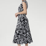 The Janine Dress in Moderno is a beautifully tailored fit-and-flare midi dress crafted from our signature high-quality, dry-touch jersey, designed to offer both elegance and comfort for any occasion. Featuring a bold geometric print in classic black and white.