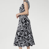The Janine Dress in Moderno is a beautifully tailored fit-and-flare midi dress crafted from our signature high-quality, dry-touch jersey, designed to offer both elegance and comfort for any occasion. Featuring a bold geometric print in classic black and white.