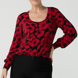 Size 10 woman wears the scoop neck bold poppy top with balloon sleeves. Curved hemline and cuffed sleeves. Made in Australia for women size 8 - 24. 