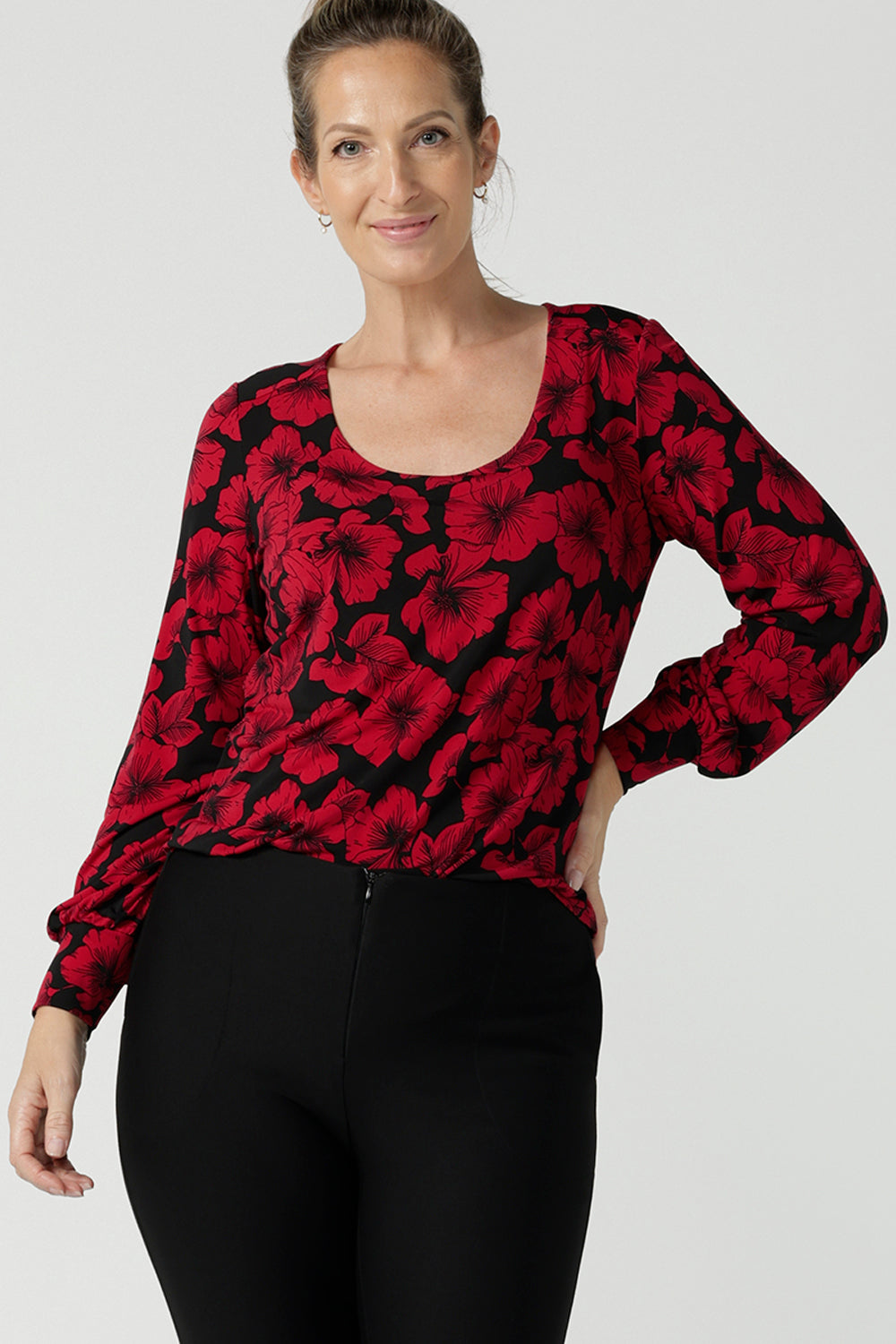 Size 10 woman wears the scoop neck bold poppy top with balloon sleeves. Curved hemline and cuffed sleeves. Made in Australia for women size 8 - 24. 