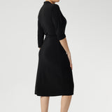 This elegant wrap dress in black jersey fabric is a timeless addition to your workwear collection, blending minimalist design with premium comfort and tailored sophistication.