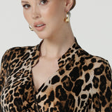 Close up of a size 10 woman wears the Jett Dress in Gold Leopard. A functioning wrap dress with a tie waist and mandarin collar. Trending Leopard print. Made in Australia for women size 8 - 24. Petite to plus size fashion.