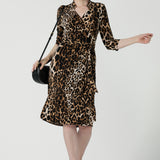 Close up of a size 10 woman wears the Jett Dress in Gold Leopard. A functioning wrap dress with a tie waist and mandarin collar. Trending Leopard print. Made in Australia for women size 8 - 24. Petite to plus size fashion.