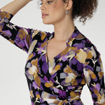 The vibrant painterly-style floral print, rich in purples and soft yellow hues, adds an artistic touch to a timeless silhouette. With its functioning wrap design, extended waist ties, and angular interlined collar, the Jett Dress brings a contemporary edge to your workwear wardrobe.