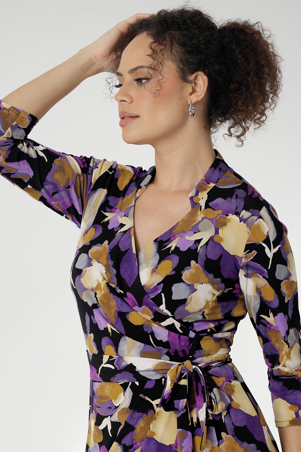 The vibrant painterly-style floral print, rich in purples and soft yellow hues, adds an artistic touch to a timeless silhouette. With its functioning wrap design, extended waist ties, and angular interlined collar, the Jett Dress brings a contemporary edge to your workwear wardrobe.