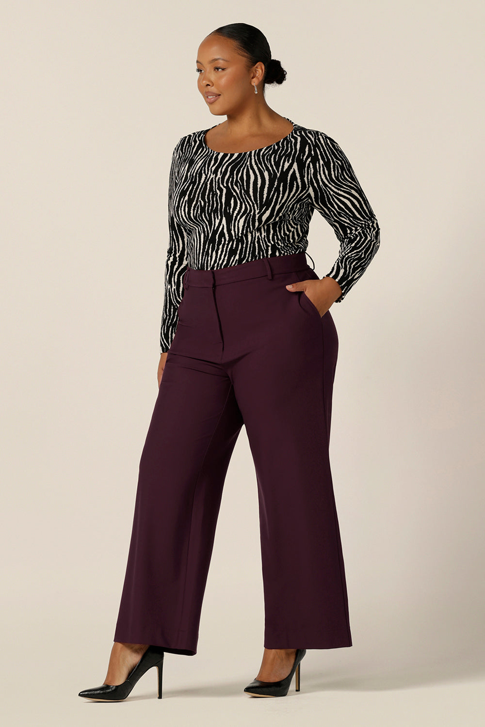A size 18, fuller figure woman wears wide leg, tailored pants in Mulberry with a zebra print long sleeve top. Australian made by Australian and New Zealand women's pants experts,L&F, these easy-care pants are comfortable for work and corporate wear.