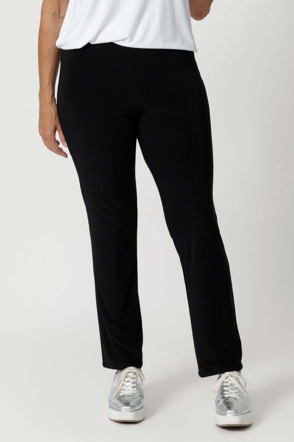 The straight-leg cut is both flattering and versatile, creating a clean, tailored silhouette that works for both casual and elevated looks. Size 12 model pairs black pants with white top & silver sneakers for a casual look.