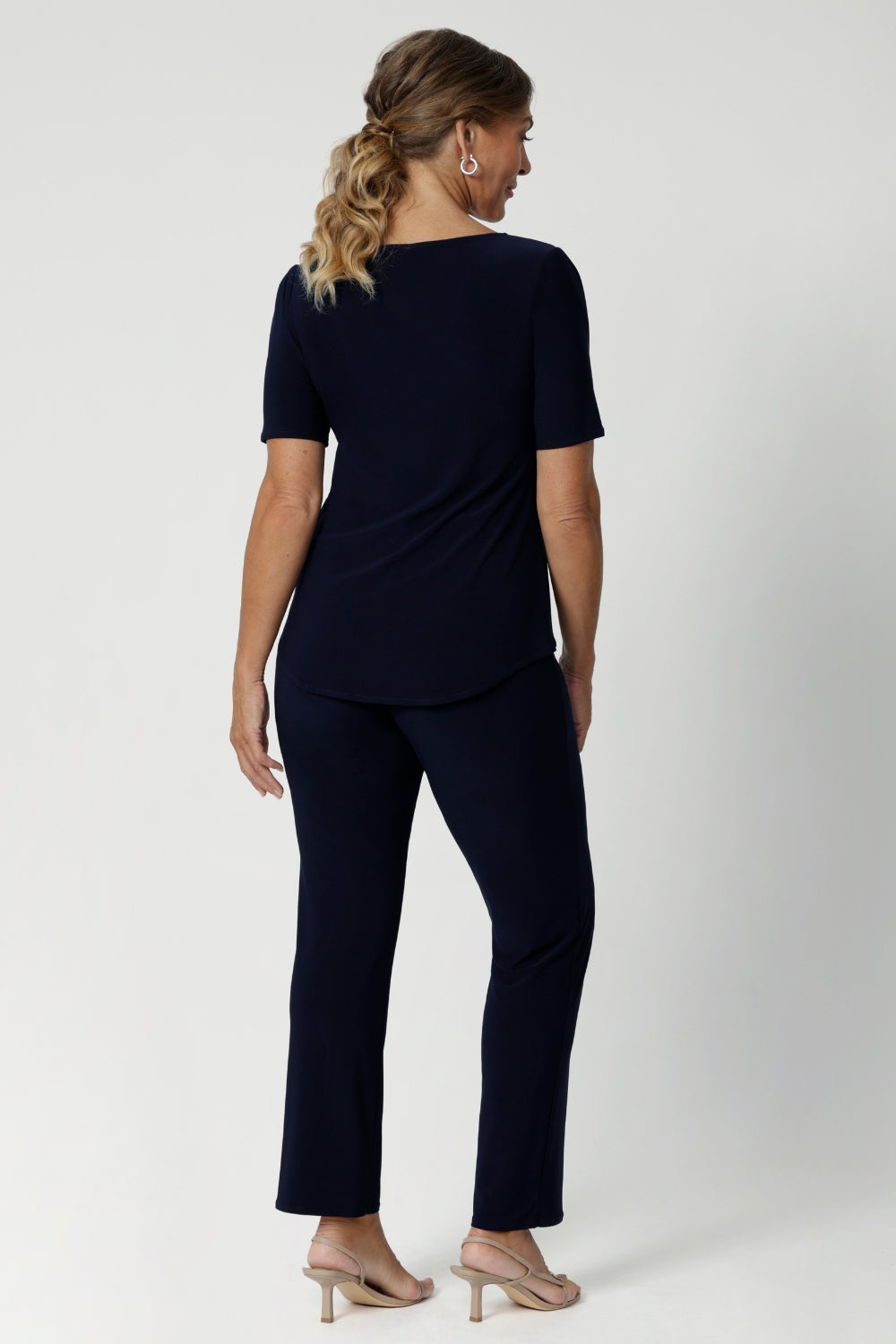 Size 12 woman wears navy workwear pants with matching navy top and a nude heel for a classic yet comfortable workwear look. Leina & Fleur stocks these pants in sizes 8-24.