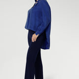 The ideal workwear pant for the combination of comfort, style, and ease. Size 10 woman wears navy workwear pants with long cobalt blouse and brown ballet flats.