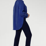 The ideal workwear pant for the combination of comfort, style, and ease. Size 10 woman wears navy workwear pants with long cobalt blouse and brown ballet flats.