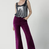 A size 10 woman wears the Jonas pant in Magenta Velveteen with a kick flare. The perfect cocktail suit set. Made in Australia for women size 8 - 24. Styled back with the Eddy Cami in Twilight. 