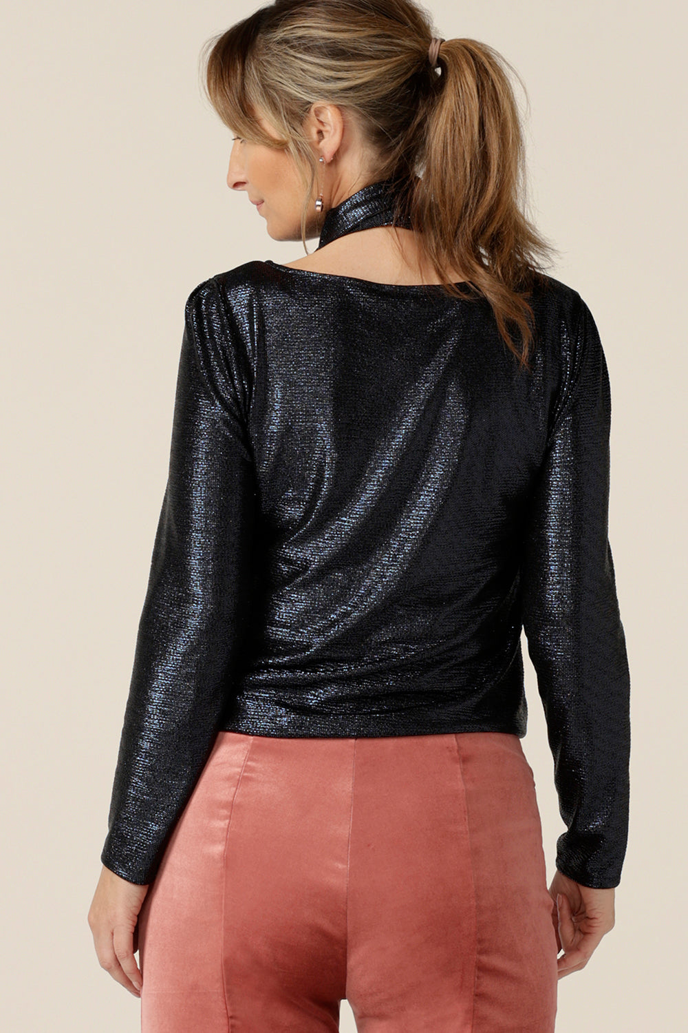 Back view of a shimmering jersey neck tie in midnight blue wrapped above a long sleeve, sparkly jersey top for an evening look with a difference. Made in Australia by women's clothing and occasionwear brand, L&F.