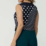 Back view of  a summer top for over 50s women, a size 12 woman wears a cowl neck jersey top. This sleeveless top has a navy and white spot print - great for corporate wear as well as casual wear! Made in Australia by Australian and New Zealand clothing brand, Leina & Fleur, shop this top in petite to plus sizes. 