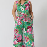 Plus sized model wears Joni Top paired with Dany Culotte in the same floral print featuring a teal-blue slinky jersey base with print details in shades of green, pink, white, yellow and brown. The fabric has a soft stretch and breathable feel. Proudly stocked in sizes 8-24 by fashion brand Leina & Fleur.