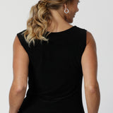 The Jordan Top is the perfect workwear piece, designed with the modern woman in mind. A woman over 40 wears the top with the cowl neckline draped at the back, creating an elegant, effortless effect. This versatile sleeveless top can also be flipped to reveal the boat-neck style, offering a more open and structured silhouette.