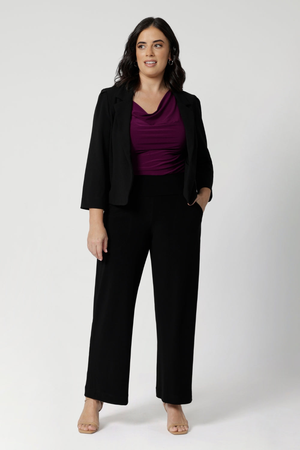 Petite height woman wears magenta coloured top that is reversible under matching black suiting. For a pop of colour that injects chic style into an everyday workwear look. Shop reversible top in 3 different colours and across a range of sizes from 8-24.