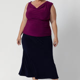 Size 18 woman wears woman's cowl neck top with twist shoulder detail. Reversible top can be worn with a cowl neckline front or boat-neck style for versatility in silhouette. Available online woman's clothing brand Leina & Fleur in sizes 8-24.